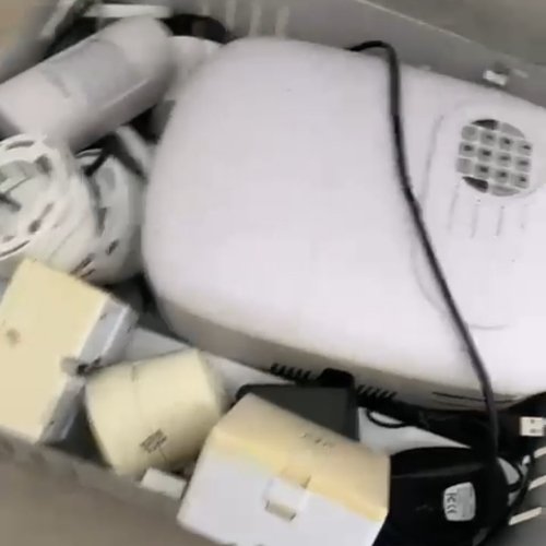 Caixa com aparelhos eletrônicos e cabos variados