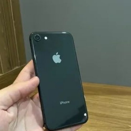 Pessoa segurando iPhone preto sobre mesa de madeira